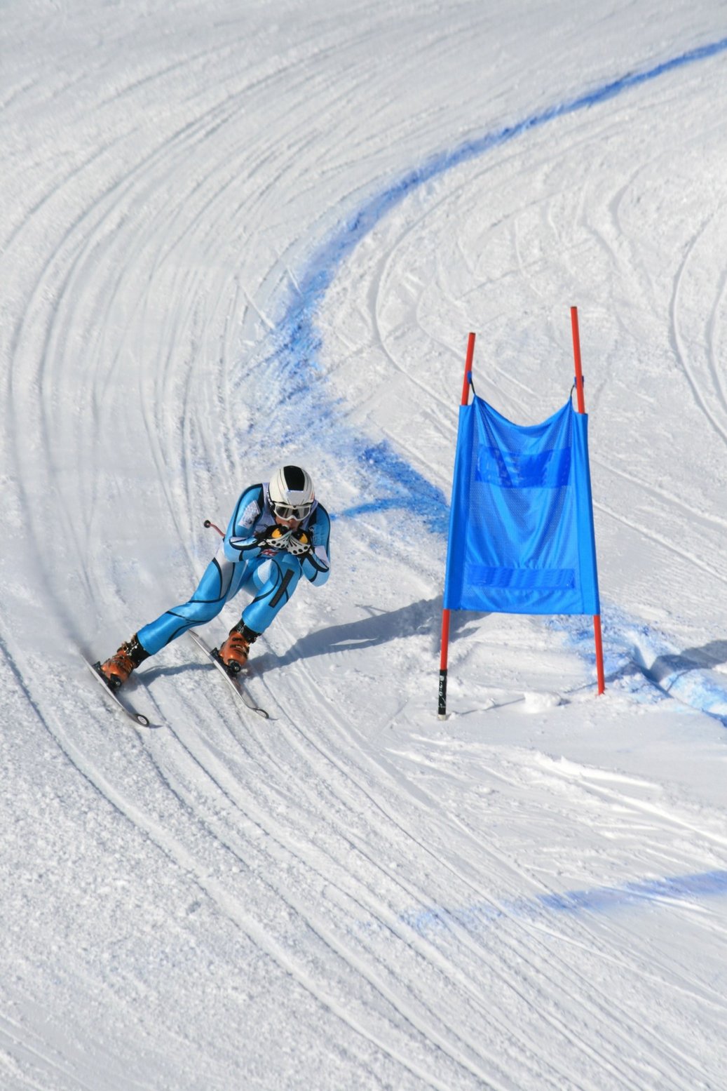 Ein Skifahrer auf einer Slalom-Piste, während er gerade ein Hindernis umfährt.
